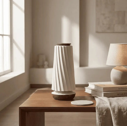 Minimalist decorative air diffuser with ceramic-style body and wood base displayed on a neutral background